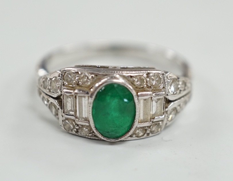 An Art Deco white metal, singe stone oval cut emerald and round and baguette cut diamond cluster set ring, size O/P, gross weight 4.2 grams.
